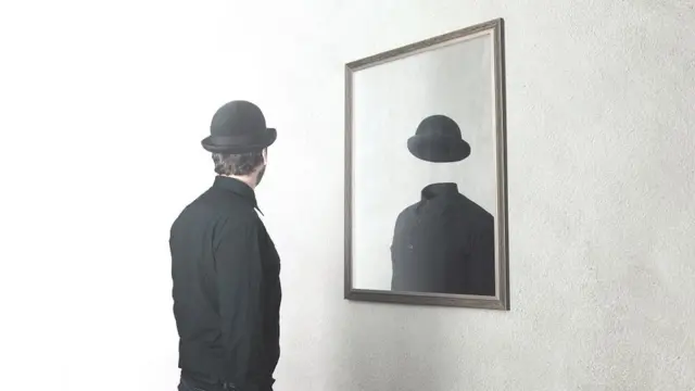 Concept photo, playing on Magritte's surreal painting ideas - man in front of mirror reflecting himself without face