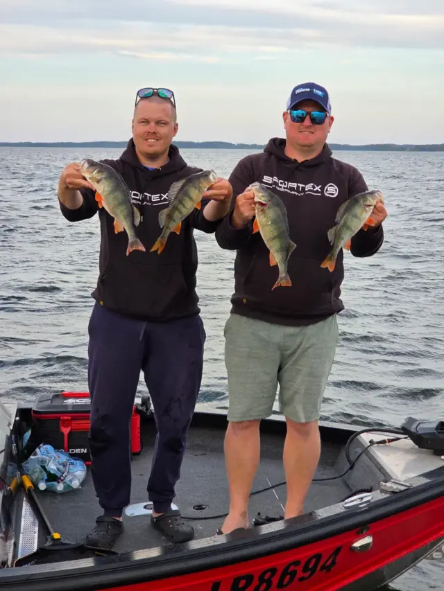 Toms Klabis i Gatis Ernstsons na čamcu drže ribe u rukama