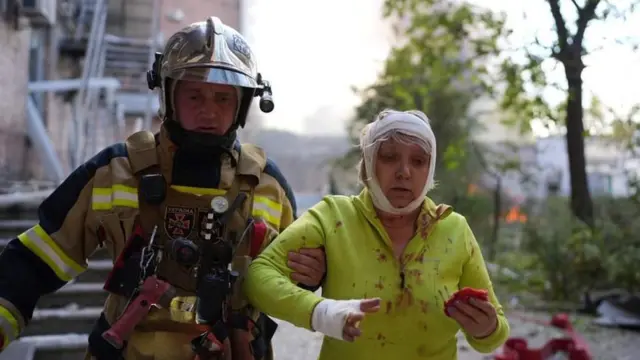 عامل إنقاذ يساعد مصابة