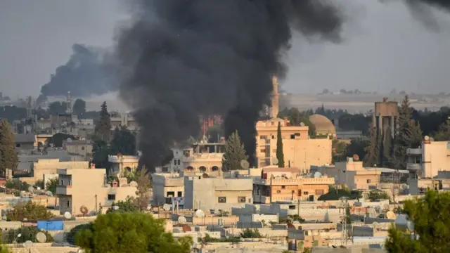 সিরিয়ার সীমান্ত শহর রাস আল-আইনের আকাশে কালো ধোঁয়া