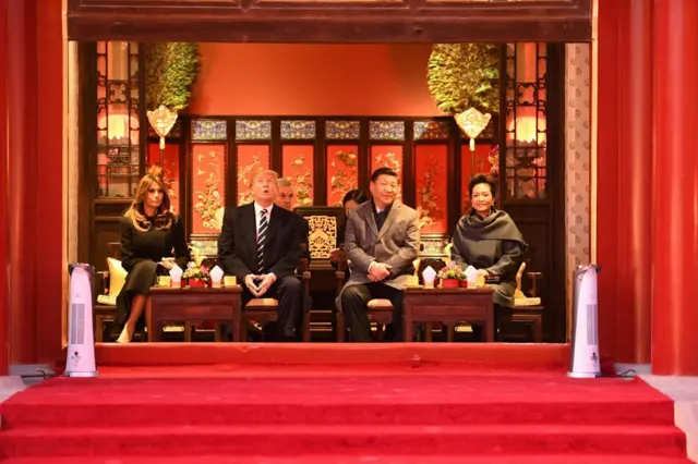 El presidente electo de Estados Unidos, Donald Trump, mira hacia arriba sentado junto a la primera dama, Melania Trump, y el presidente de China, Xi Jinping, y su esposa, Peng Liyuan, durante una visita a la Ciudad Prohibida en Beijing el 8 de noviembre de 2017.