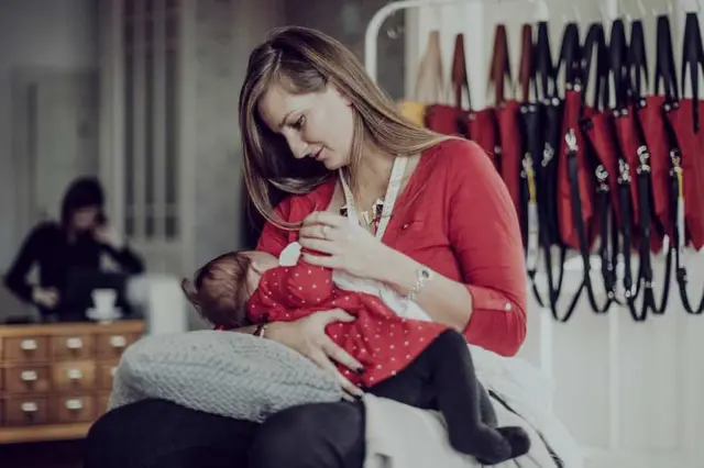 Ibu menyusui anaknya di sebuah pusat keramaian.