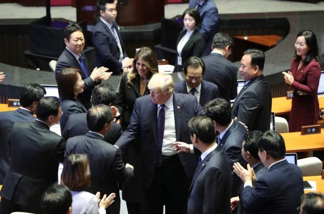 特朗普和夫人梅拉尼娅在韩国国会与议员握手。