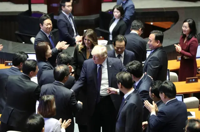特朗普和夫人梅拉尼娅在韩国国会与议员握手。