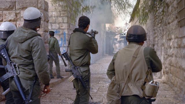 A polícia israelense dispara gás lacrimogêneo contra manifestantes palestinos durante confrontos, em 22 de janeiro de 1988, nas ruas de Jerusalém, após as orações de sexta-feira.