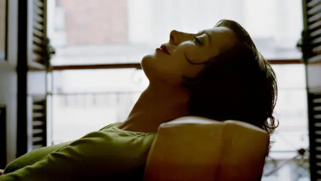 Žena leži na kauču zatvorenih očiju