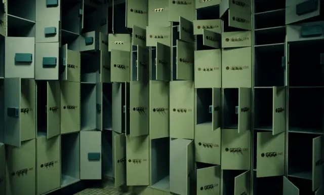 Fila de casilleros metálicos abiertos y vacíos, con cerraduras visibles en una sala iluminada