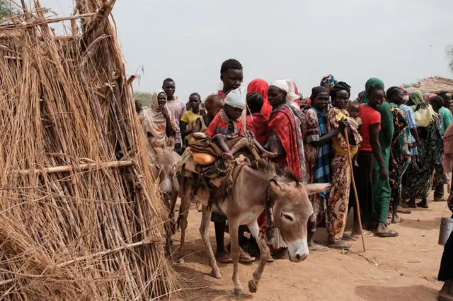 طابور طويل من السودانيين يصطفون للحصول على معونات غذائية للأمم المتحدة في أحد مراكز النازحين.