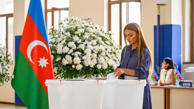 Азербайджанская избирательница бросает свой бюллетень в урну 1 сентября 2024 года