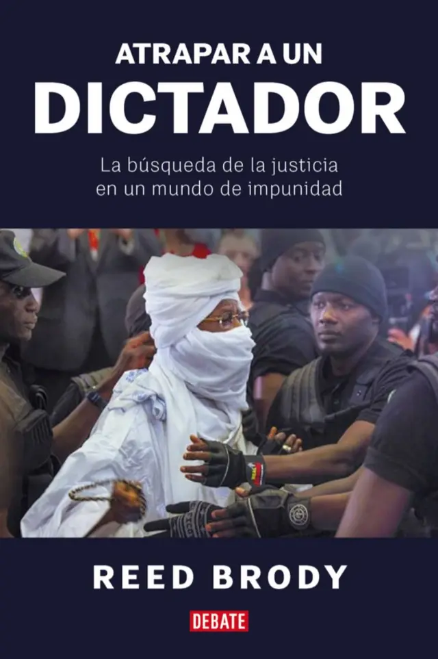 Portada del libro "Atrapar a un dictador" en la que se ve a Hissène Habré vestido con un boubou o túnica blanca, y con la cara y la cabeza cubiertas. Está rodeado de varios agentes de seguridad