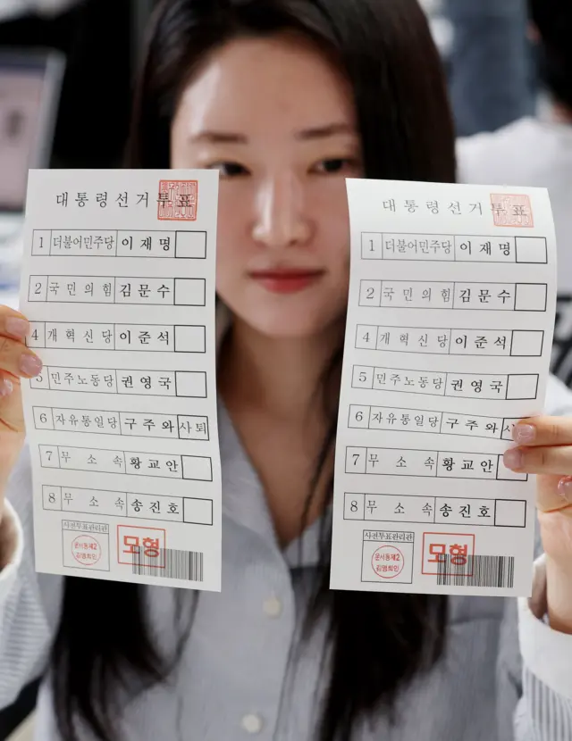 투표 용지를 보여주는 선관위 관계자