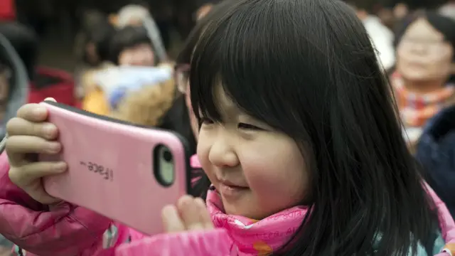 Un enfant tenant un smartphone.