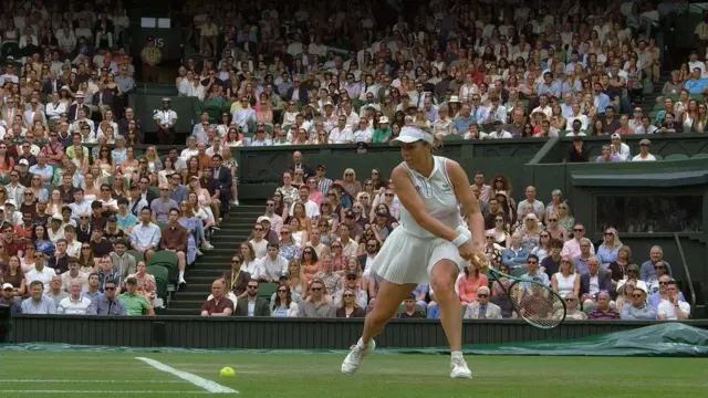 ソネイ・カータル選手の打った黄色いボールが芝生に落ちた瞬間。アナスタシア・パヴリュチェンコワ選手が打ち返そうとラケットを両手で引いている