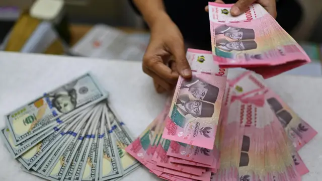 Karyawan menghitung uang pecahan rupiah dan dolar Amerika Serikat (AS) di gerai penukaran mata uang asing Ayu Masagung, Jakarta, Selasa (12/5/2026). Nilai tukar rupiah terhadap dolar AS pada penutupan perdagangan Selasa (12/5) melemah 115 poin atau 0,66 persen menjadi Rp17.529 per dolar AS dari penutupan sebelumnya di level Rp17.414 per dolar AS, terpengaruh ekspektasi suku bunga tinggi The Fed yang lebih lama.