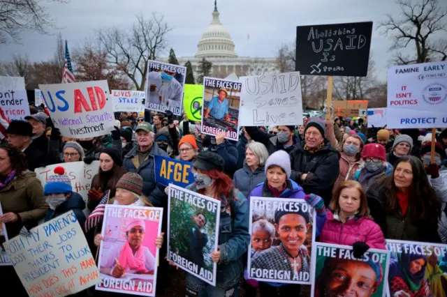 ผู้สนับสนุนและเจ้าหน้าที่ USAID ชุมนุมนอกอาคารรัฐสภาสหรัฐฯ เมื่อ 5 ก.พ. ประท้วงการปิดหน่วยงานกะทันหันของรัฐบาลทรัมป์ ส่งผลให้งานด้านบรรเทาทุกข์ การป้องกันความขัดแย้ง และนโยบายต่างประเทศทั่วโลกถูกยกเลิก และอาจต้องเลิกจ้างพนักงานหลายพันคน