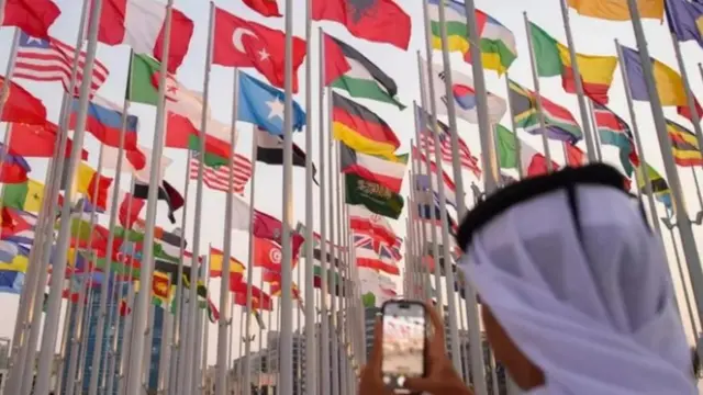 قطري يصور أعلام الدول المشاركة في كأس العالم