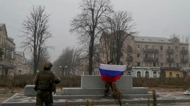 Sojojin Rasha, ɗaya na riƙe da tutar ƙasar.