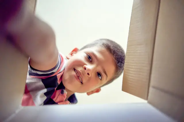Un niño mira dentro de una caja