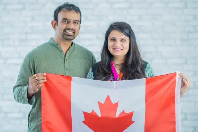 કૅનેડાના રાષ્ટ્રીયધ્વજ સાથે ભારતીય દંપતીની પ્રતીકાત્મક તસવીર