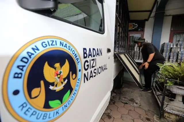 Pekerja Badan Gizi Nasional (BGN) menurunkan baki makanan dari sebuah truk di Banda Aceh, Indonesia, 31 Maret 2026.