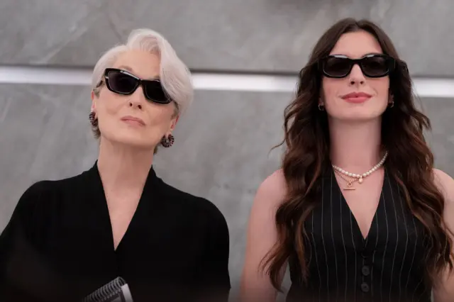Picture of Meryl Streep and Anne Hathaway both in black sunglasses and black outfits, taken from a still of Devil Wears Prada 2