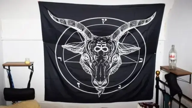 اتاق خواب که یک پارچه سیاه روی دیوار نصب شده، روی پارچه با رنگ سفید سر یک گاو دیده می‌شود و علائمی خاص