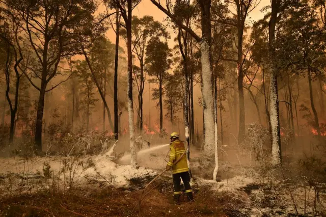 A firefighter sprays foam retardant