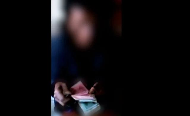 A North Korean counts the money after receiving the delivery from the brokers