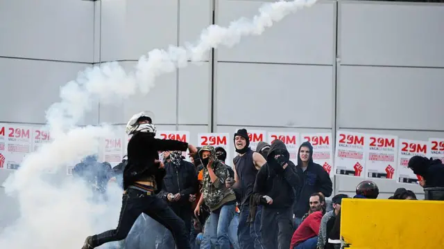 Un manifestante devuelve una bomba de gas lacrimógeno durante una huelga de 24 horas el 29 de marzo de 2012 en Barcelona, ​​España. 