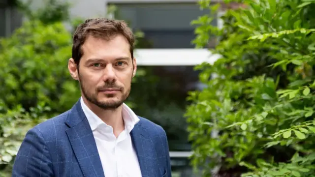 فابيو ساتولو يرتدي بدلة زرقاء وقميصاً أبيض