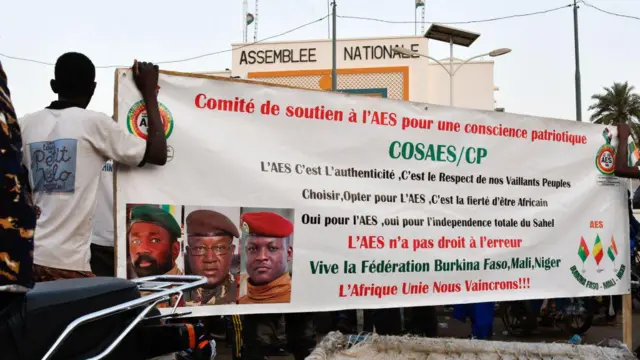 Supporters of di Alliance Of Sahel States (AES) hold up dia banner as dem dey celebrate Mali, Burkina Faso and Niger leaving di Economic Community of West African States (ECOWAS) in Niamey on January 28, 2024. 