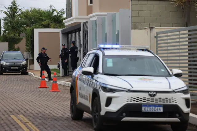 Policiais fazem a segurança da casa do ex-presidente brasileiro Jair Bolsonaro enquanto ele cumpre prisão domiciliar.