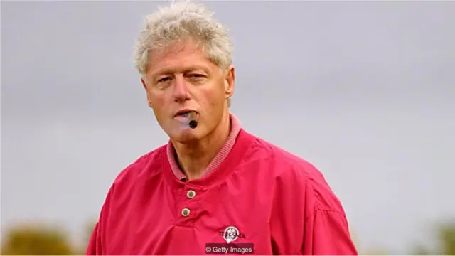 Bill Clinton fuma um charuto