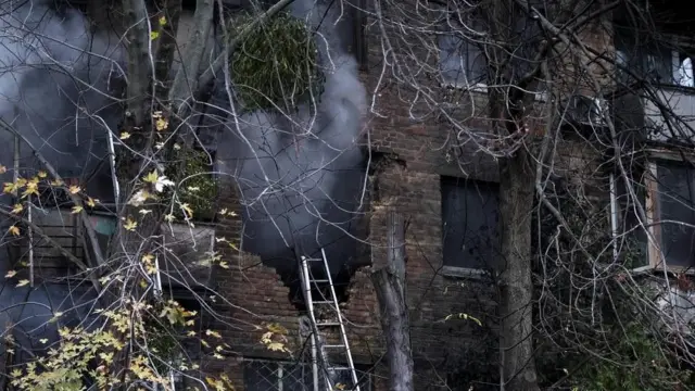  মিসাইল হামলার পর বিধ্বস্ত একটি বাড়ি থেকে ধোঁয়া উঠছে।