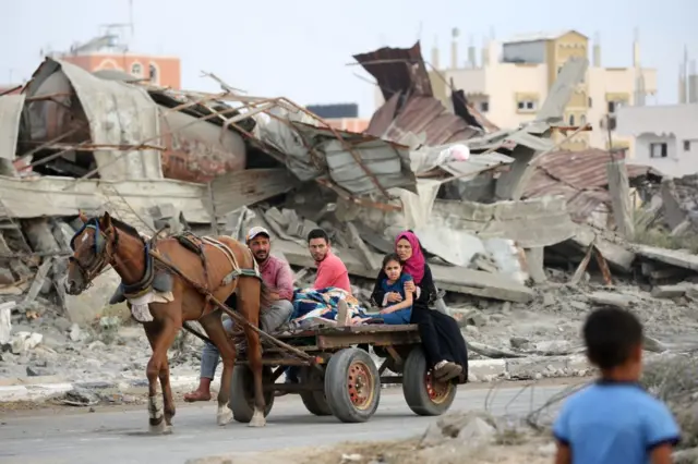 عائلة فلسطينية في عربة يجرها حصان بعد فرارهم من مخيم المغازي للاجئين الفلسطينيين في 17 أغسطس/آب 2024