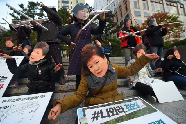 அதிபரை தோழியான சோய் சூன்-சில் ஆட்டுவிப்பது போன்று போராட்டகாரர்கள் வடிவமைப்பு