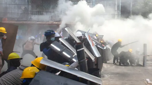 反军事政变的示威者在躲避安全部队的催泪气体。