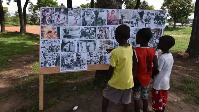 Children look at a placard on May 30, 2017 in Abidjan, during commemorations of the 50th anniversary of the Nigerian civil war. Nigeria on May 30 marks 50 years since the declaration of an independent Republic of Biafra plunged the country into a civil war, amid renewed tensions and fresh calls for a separate state. The main pro-independence groups - the Indigenous People of Biafra (IPOB), and the Movement for the Actualisation of the Sovereign State of Biafra (MASSOB) - have called for a day of reflection.