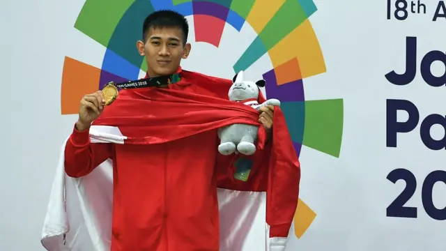 Pesilat Indonesia peraih medali emas Iqbal Chandra Pratama berpose usai upacara penyerahan medali Kelas D Putra Asian Games 2018 di Padepokan Pencak Silat Taman Mini Indonesia Indah (TMII), Jakarta, Senin (27/8).