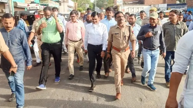 शहर में मार्च करते अधिकारी