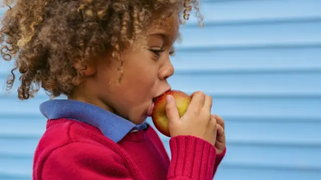 Menino comendo maçã