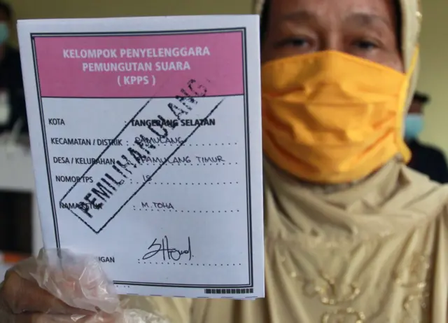 Seorang pemilih menunjukan surat suara pemilihan suara ulang (PSU) Kota Tangerang Selatan di TPS 15 Pamulang Timur, Pamulang, Tangerang Selatan, Banten, Minggu (13/12)