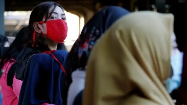 Penumpang kereta di Jakarta menggunakan masker.