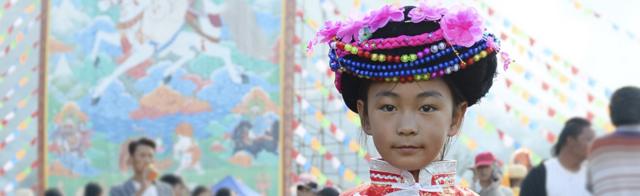 在宁蒗彝族自治县，一名小女孩身着民族服装参加转山节活动（新华社图片4/9/2018）