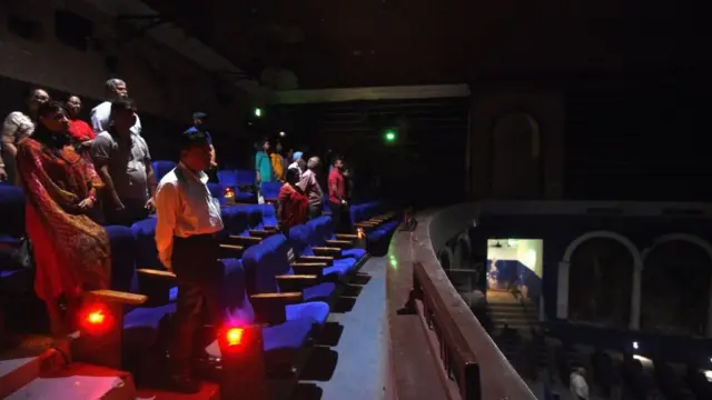 રાષ્ટ્રગાન સમયે સિનેમા હૉલમાં ઉભેલા લોકો