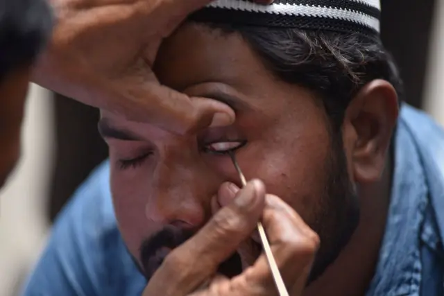 রমজান মাসে নামাজ পড়ার আগে নেপালের এক মুসলিম পুরুষ তার চোখে ভেষজ 'সুরমা' লাগিয়ে নিচ্ছেন