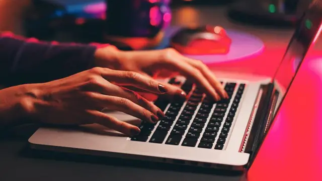 يدا امرأة تكتب على لوحة مفاتيح لابتوب