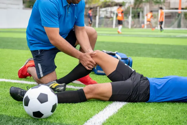 Un jugador de fútbol siendo atendido después de lesionarse