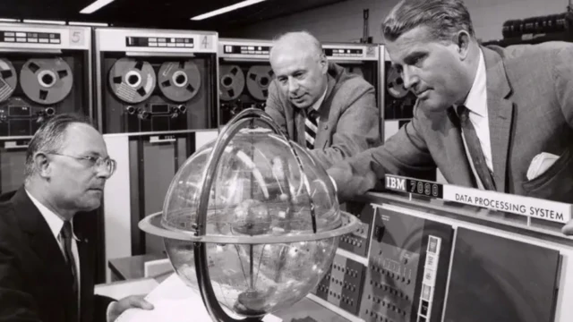 سه نفر در حال بررسی یک کره شیشه‌ای در یک آزمایشگاه فیزیک هستند