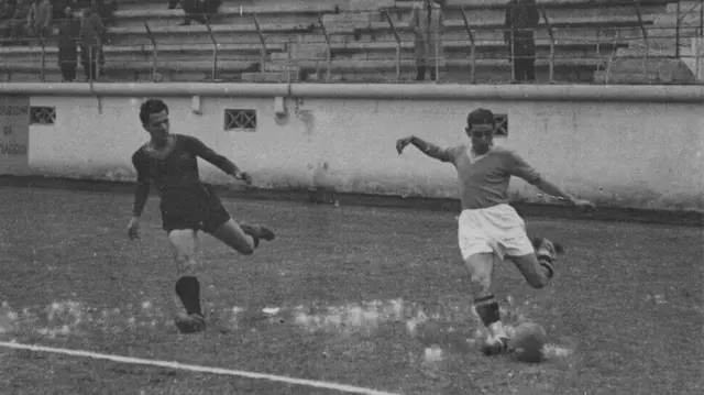 Guarisi se prepara para chutar a bola, observado por um adversário, durante uma partida da equipe italiana Lazio